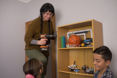 Persons secures bookshelf in a childrens room