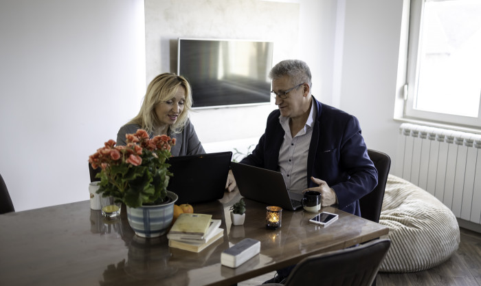 couple look at documents together on laptops
