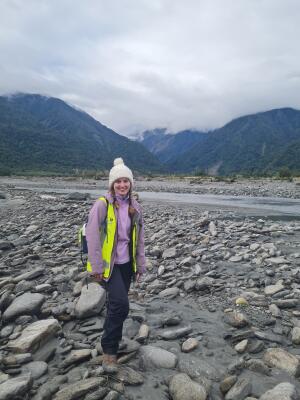 Niamh standing by a river with mountains in the background.