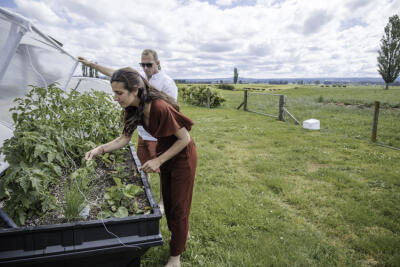 A young couple gardening in their rural section.