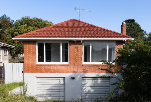 The outside of a two storey house, with brick and masonry walls.