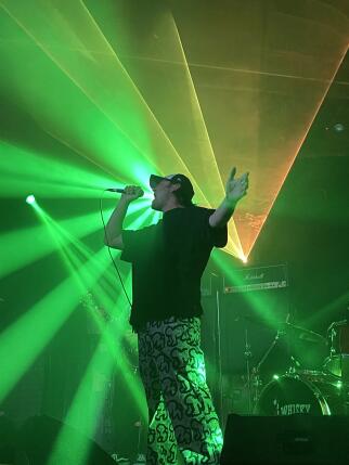 Man on stage singing with strobe lights