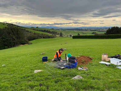 Two people installing seismic monitoring equipment