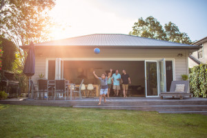 View of the back deck of a New Zealand house with a family coming out of it