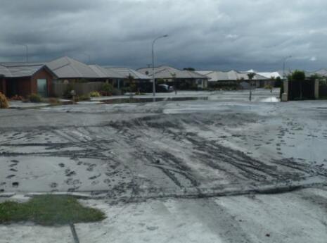 Photo showing liquefaction damage to a street.