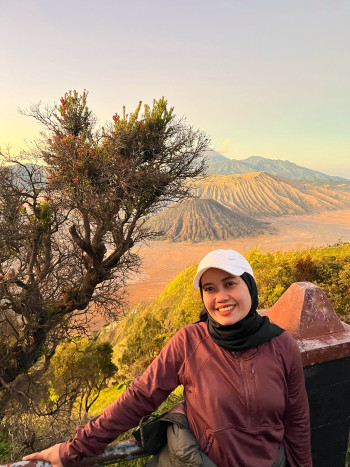 Student Indri Apriani stands in front of a volcano
