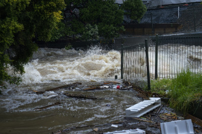 Flood waters rush through a gate