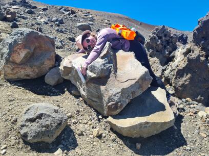 Niamh hugging a rock on a mountain.