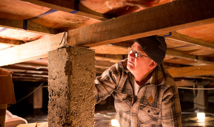 Man checks foundations under the house