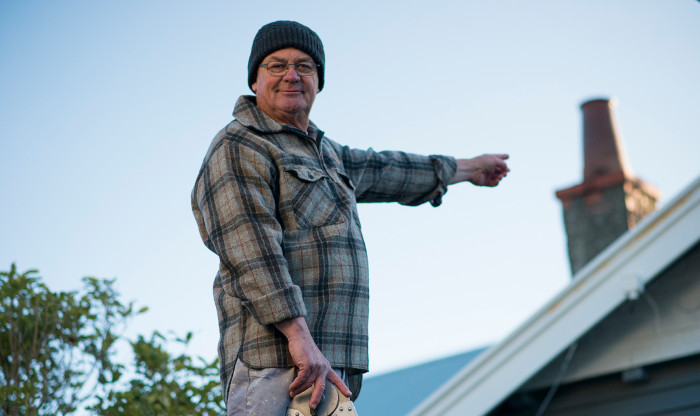 Person pointing to a chimney on a roof